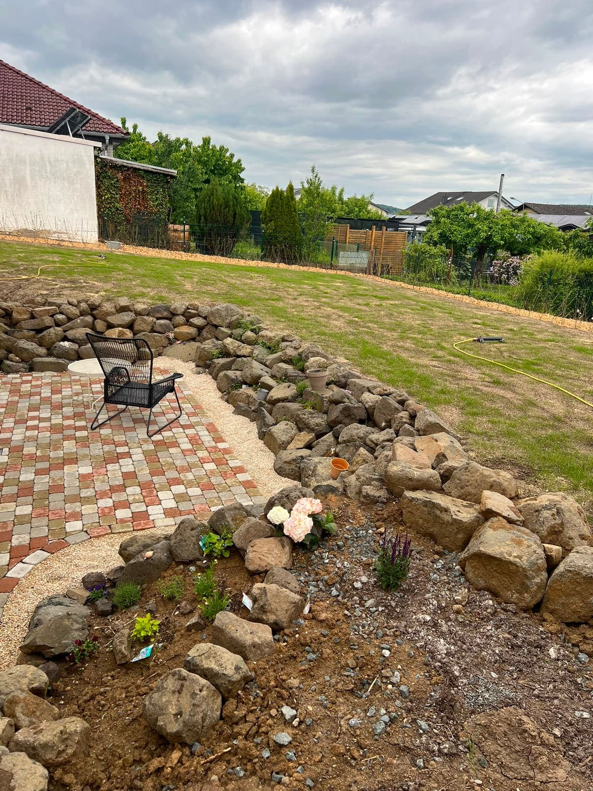 Gartengestaltung in Wetzlar – Natursteinmauer mit neu angelegtem Beet und Pflasterterrasse